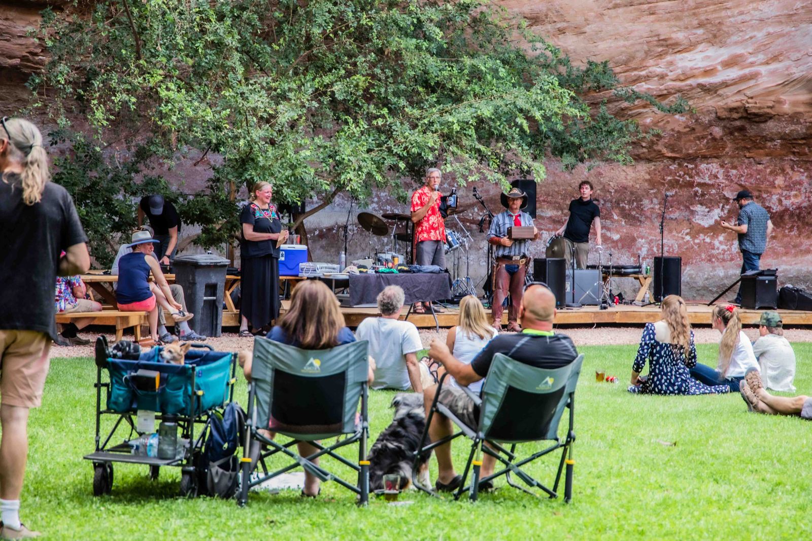 Live band on the stage at Dreamland's 20th anniversary party in 2021, guests on the lawn below red sandstone cliffs