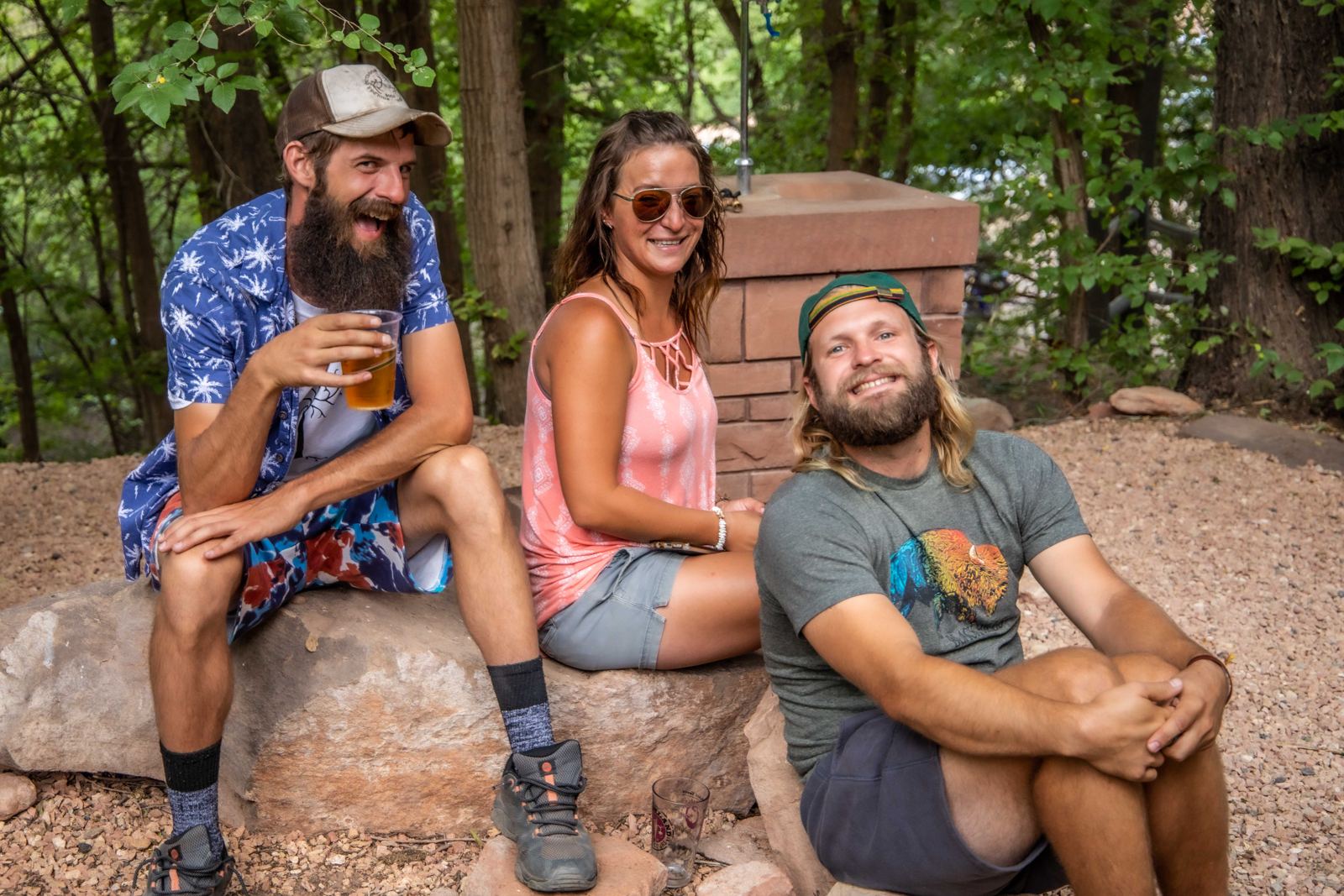 Friends laughing together on a stone wall at Dreamland's 20th anniversary party in 2021