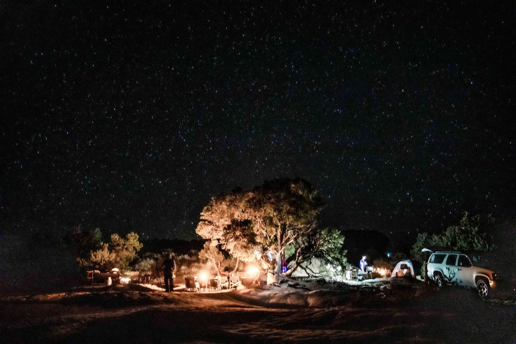 The Milky Way arching over the swirled red-and-cream sandstone of White Pocket at night
